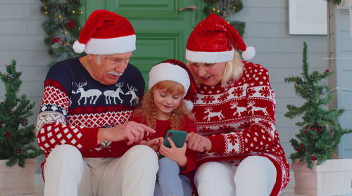 Smiling grandparents with granddaughter talking on video call