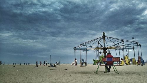 People playing on beach against sky