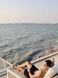 Rear view of woman sitting on boat in sea