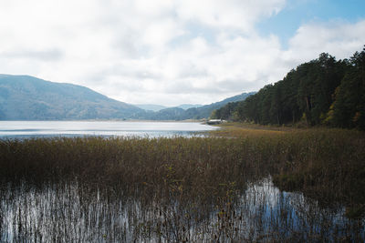 Scenic view of lake and mountains against sky