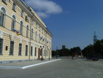 Street amidst buildings against blue sky