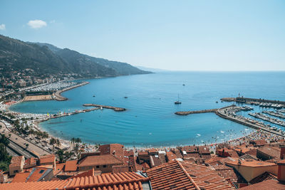 Aerial view of sea by city against sky