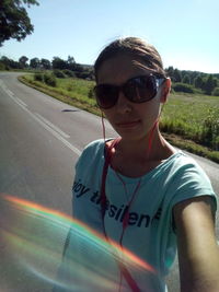 Portrait of man wearing sunglasses against road