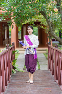 Full length portrait of woman standing outdoors