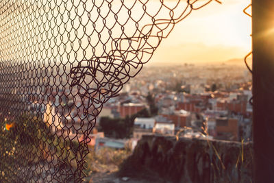 Town seen from broken chainlink fence at morning
