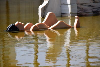 Low section of woman lying in water