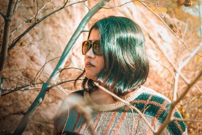 Close-up of woman wearing sunglasses standing in forest