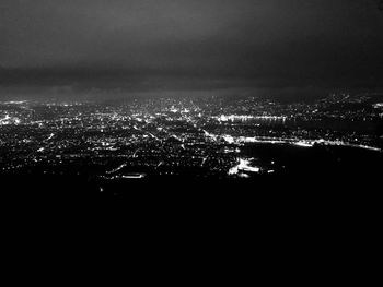 Illuminated cityscape against sky at night