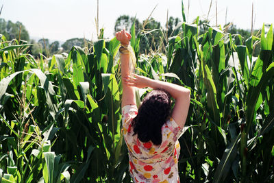 Rear view of woman standing in field