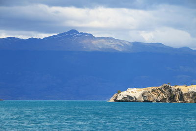 Scenic view of sea and mountains against sky