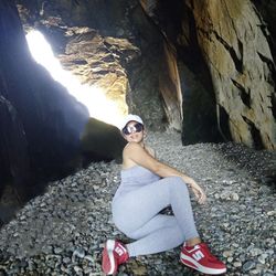 Portrait of young woman sitting on rock