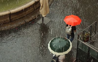 High angle view of woman walking with umbrella