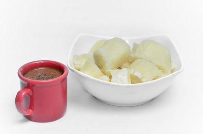 Close-up of fruits in bowl over white background
