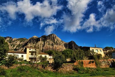 Scenic view of houses and trees against sky