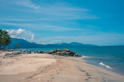 Scenic view of beach against blue sky
