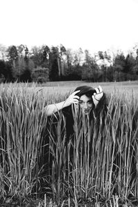 Midsection of woman in field against clear sky