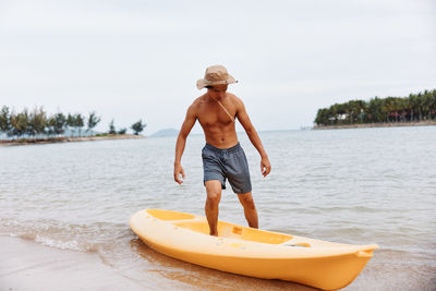 Rear view of man standing in boat