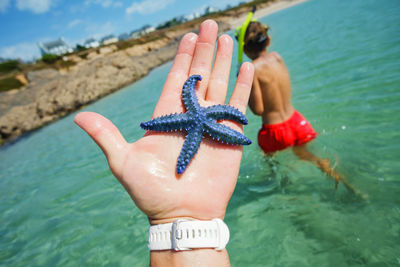 Cropped hand of woman swimming in sea