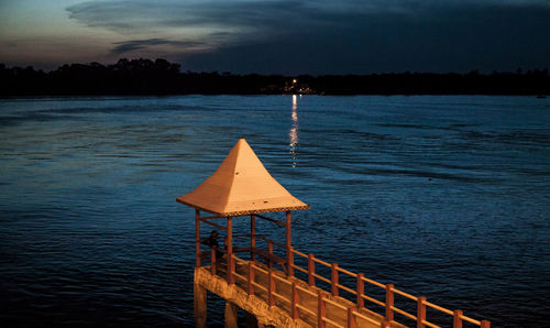 Pier over sea against sky during sunset