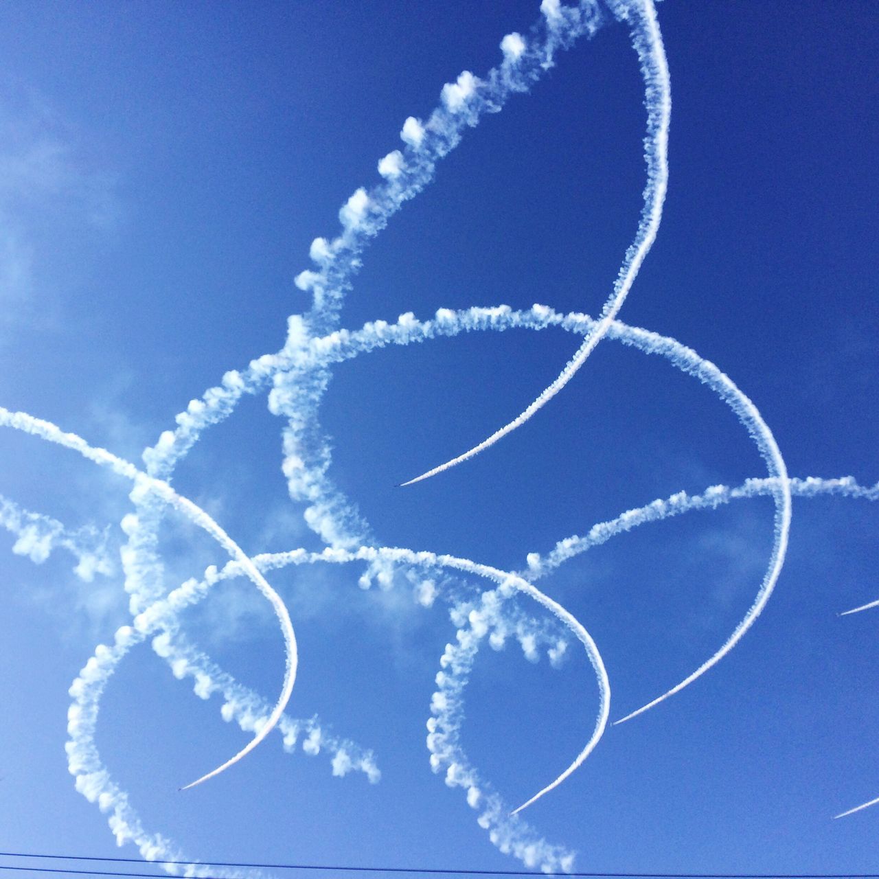 blue, low angle view, sky, mid-air, circle, no people, outdoors, motion, day, white color, bubble, nature, sport, close-up, beauty in nature, flying, sphere, shape, pattern, clear sky