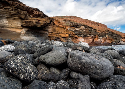 Rocks on beach against sky