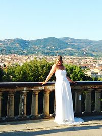 Woman with arms outstretched against clear sky