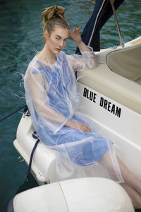 High angle view of young woman wearing workwear sitting in boat