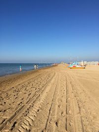 Scenic view of beach against clear blue sky