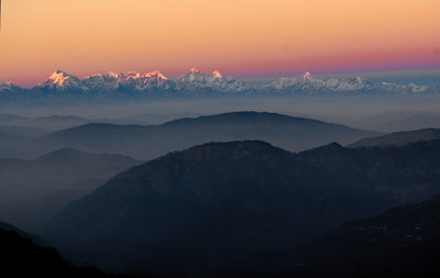 Scenic view of silhouettes mountains against romantic sky at sunset