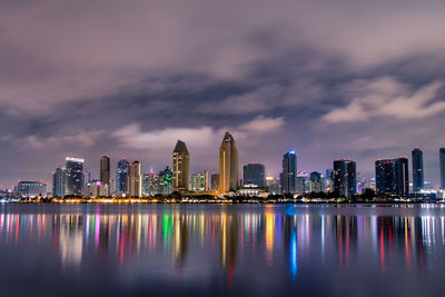 Illuminated buildings by city against sky