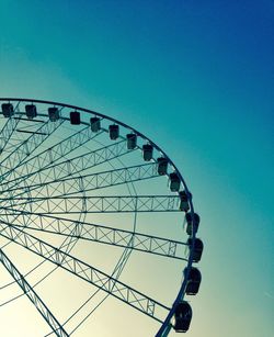 Low angle view of ferris wheel against blue sky