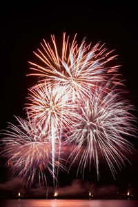 Low angle view of firework display at night