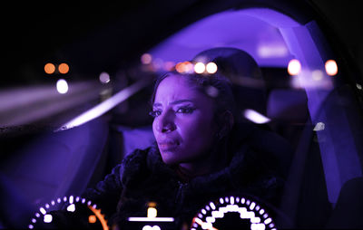 Portrait of young woman looking away at night