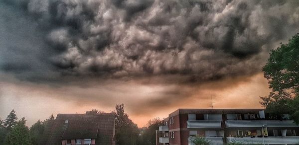 Low angle view of buildings against dramatic sky