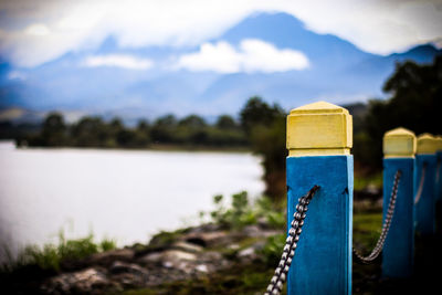 Close-up of wooden post in lake against sky