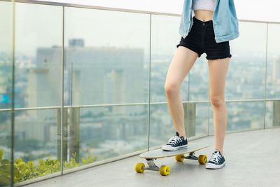 Low section of person standing on glass window