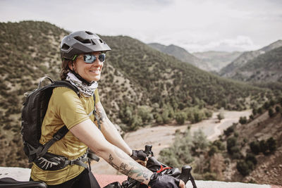 Female cyclist smiles while biking thru the atlas mountains, morocco