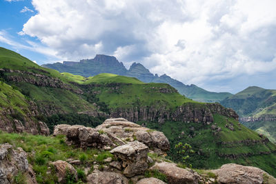 Long shot view of champagne castle of drakensberg mountains in a summer hike with rain clouds 
