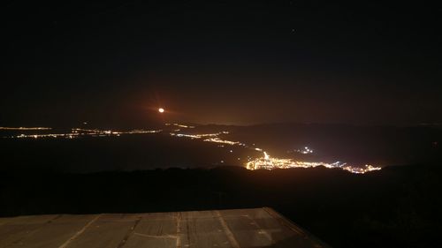 Illuminated city against sky at night