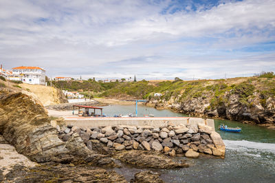 Scenic view of sea by rocks against sky