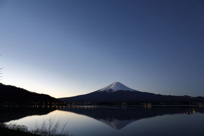 Scenic view of lake against clear blue sky at night