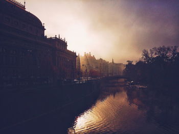 Reflection of buildings in river at sunset