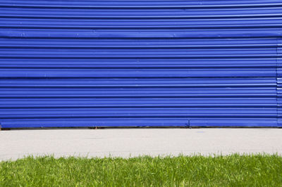 Closed blue shutter by field