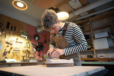 Rear view of young man working in workshop