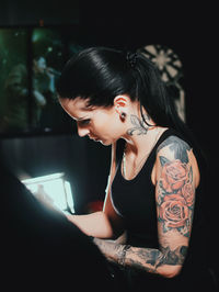 Side view of young woman sitting on table