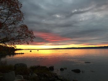 Scenic view of sea against cloudy sky at sunset