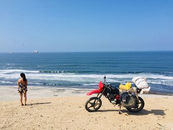 People on beach against clear sky