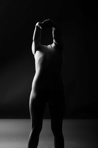 Midsection of man standing against black background