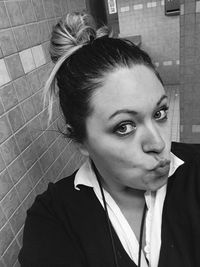 Close-up portrait of young woman puckering in bathroom