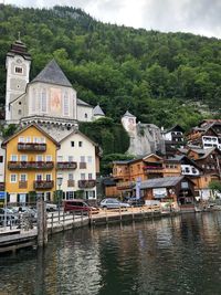 Houses by river against buildings in city